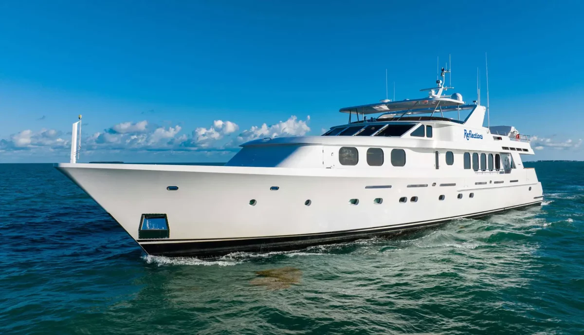 Reflections Motor Yacht cruising on open waters under a blue sky.