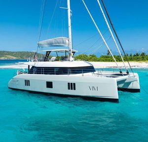 Vivi Sailing Catamaran anchored next to a beautiful beach with turquoise water