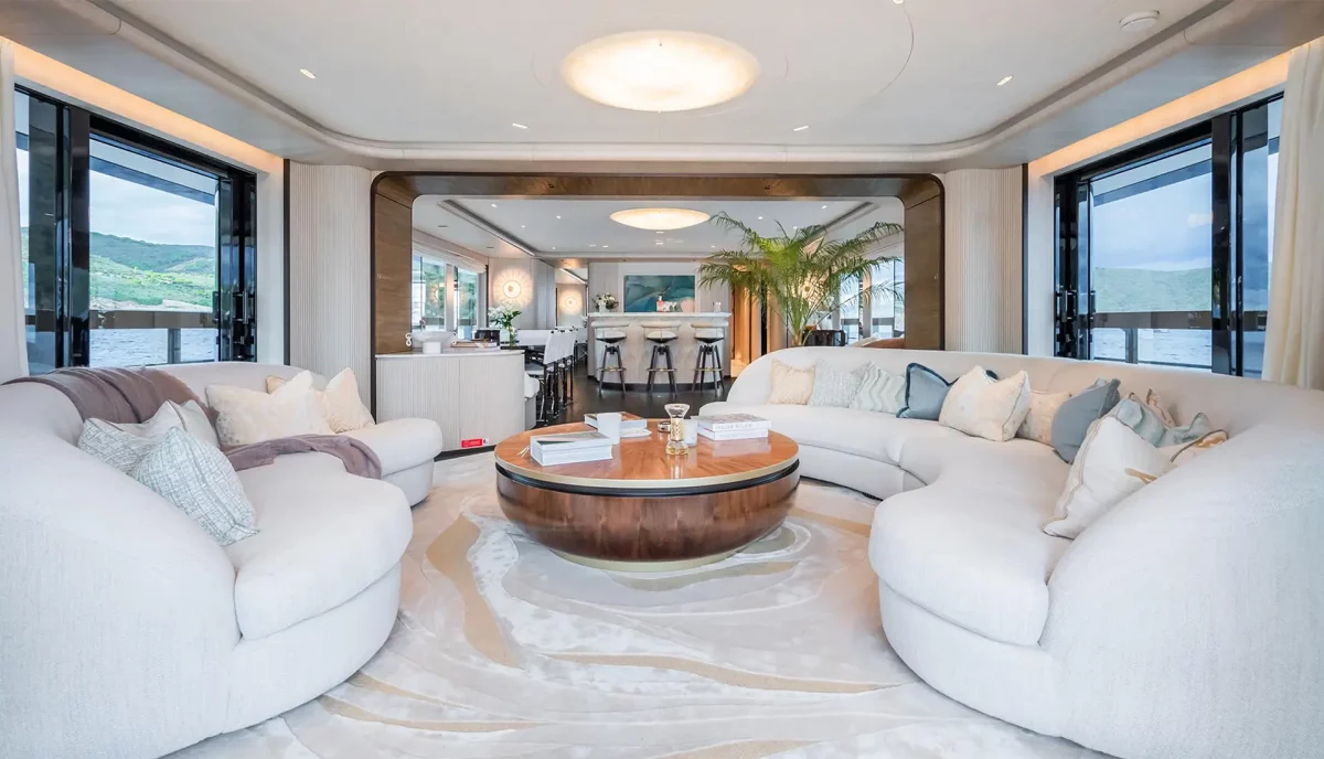 Curved sofa lounge with wood coffee table in main salon of M yacht