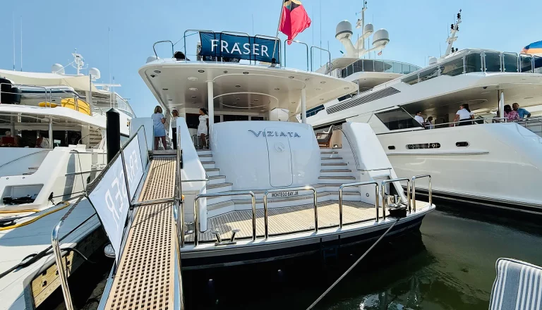 Stern of Viziata motor yacht at dock with ramp and flag
