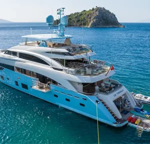 Aerial view of LE VERSEAU showcasing multi-level decks and tenders in the blue waters of Greece.